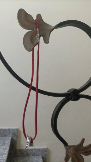 Colgante con cadena roja y figura plateada