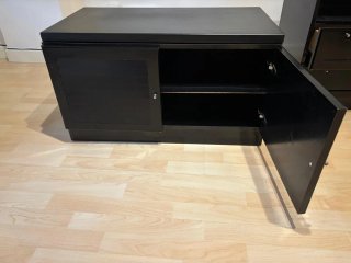 Mueble de salón negro con puertas de cristal