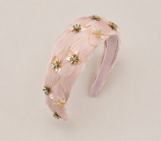 Diadema de plumas rosa y detalles dorados