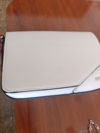 Cartera de mano blanca con ribete negro