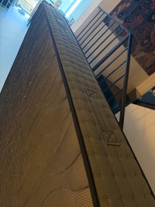 Cama con colchón de tela y madera