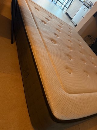 Cama con colchón de tela y madera