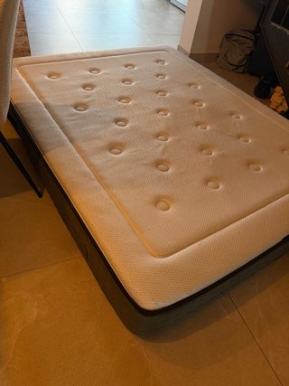 Cama con colchón de tela y madera