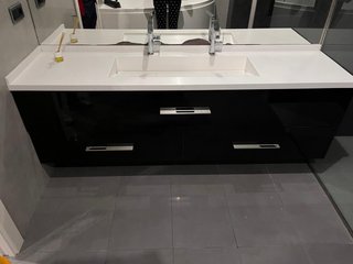 Mueble de baño negro con lavabo y grifos