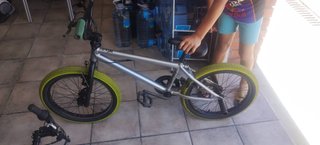 Bicicleta BMX plateada con ruedas amarillas