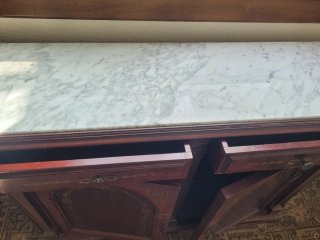 Mueble de madera con mármol y detalles dorados