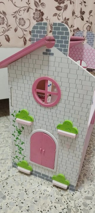Casa de muñecas rosa con muebles