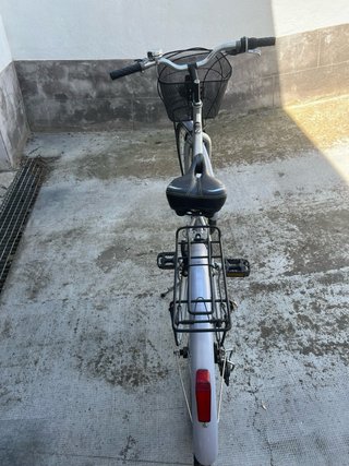 Bicicleta de ciudad plateada con cesta