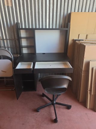 Escritorio negro con silla y estanterías