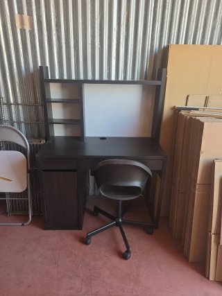 Escritorio negro con silla y estanterías