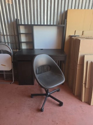 Escritorio negro con silla y estanterías