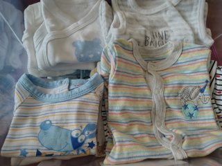 Saco de bebé con ositos y nubes y ropa de bebé