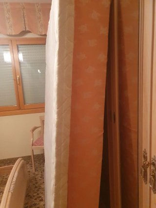 Cama de madera rosa claro, base tapizada y colchón