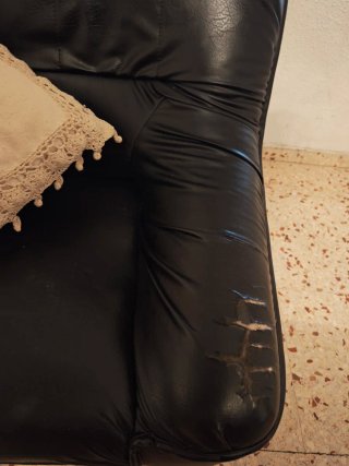 Sofá de piel vintage negro con rasgones