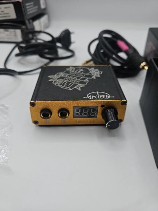Maquina de tatuaje con pedal y fuente de poder.