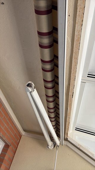 Toldo de tela beige y rojo con volante .