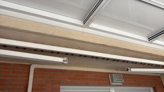 Toldo de tela beige y rojo con volante .