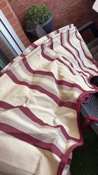 Toldo de tela beige y rojo con volante .