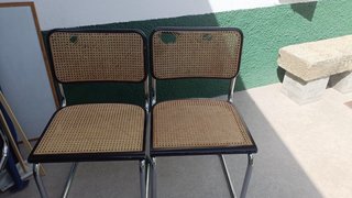 Mesa de comedor de cristal con sillas de mimbre