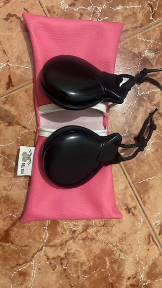 Castañuelas negras con funda rosa