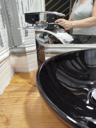 Lavabo de ceramica negro con grifo alto de cascada