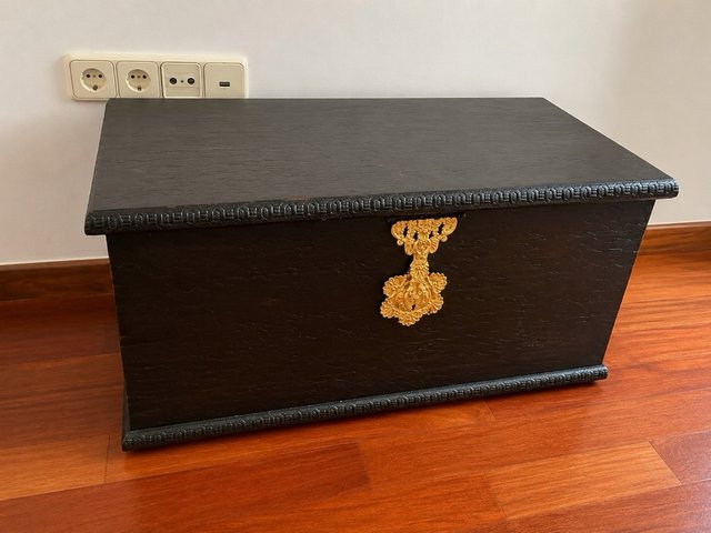 Baúl de madera y metal negro con detalle dorado