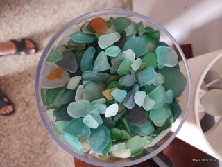 Jarrón con cristales de mar verdes y transparentes