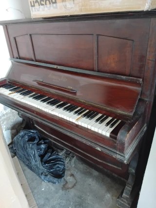 Piano de pared de madera oscura
