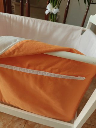 Cuna de bebé blanca con cesta naranja