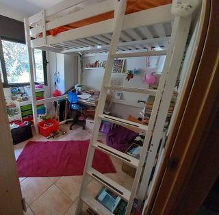 Cama alta blanca con espacio debajo