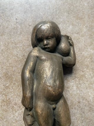 Escultura antigua de niño con jarra