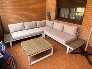 Sofá gris y mesa de jardín marrón.