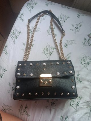 Bolso negro con tachas y perlas doradas