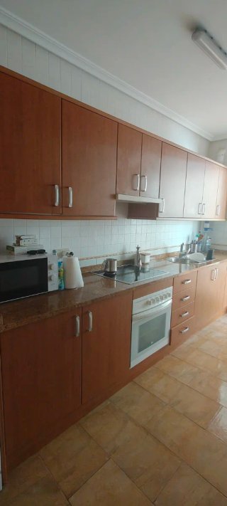 Cocina completa madera con electrodomésticos.