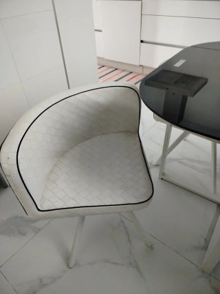 Mesa cuadrada de cristal y 4 sillas blancas.