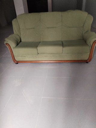 Sofá de tela verde con detalles de madera