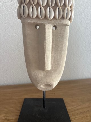 Cabeza decorativa de piedra con conchas
