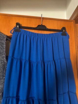 Gonna blu, top argento, borsetta bordeaux