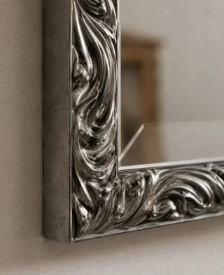 Espejo decorativo plateado con marco ornamentado
