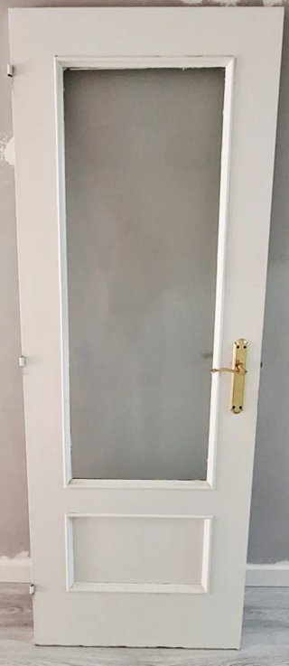 Puerta blanca con cristal y manilla dorada