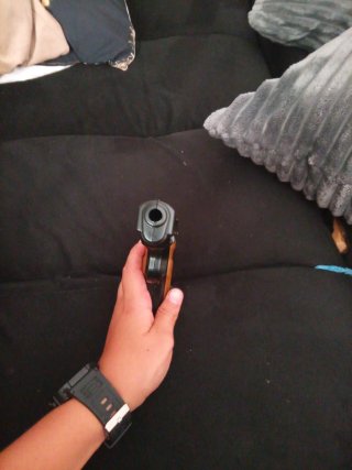 Pistola de juguete con cachas naranjas