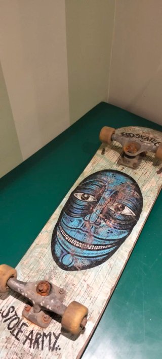 Skate con diseño de cara y STOLE ARMY