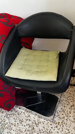 Sillón de peluquería negro con cojín verde