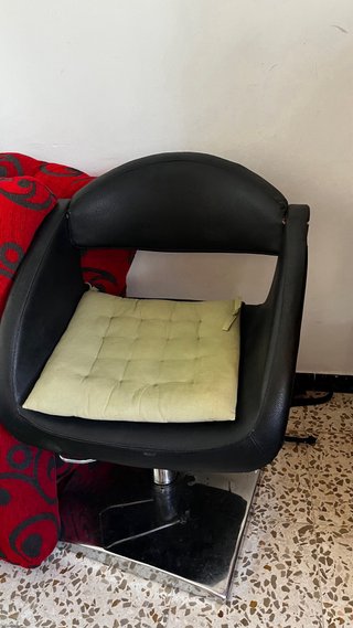 Sillón de peluquería negro con cojín verde