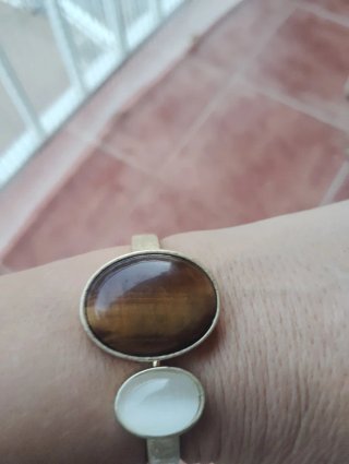 Pulsera dorada con piedras marrones y blancas