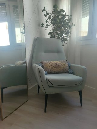 Sillón de tela verde mint con ribete negro