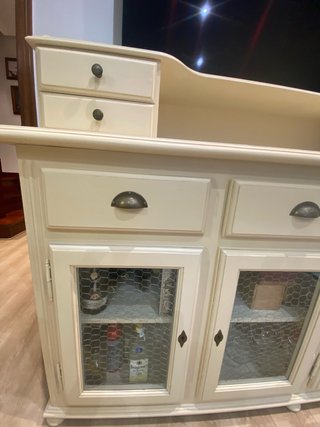 Aparador beige con puertas de cristal.