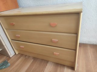 Cómoda de madera beige con tiradores naranjas