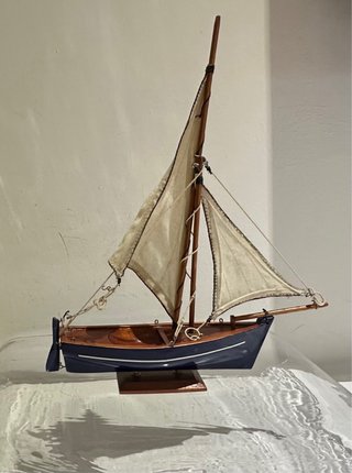 Barca a vela blu in legno con vele in cotone