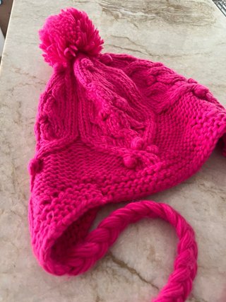 Gorro de lana rosa con pompón y trenzas